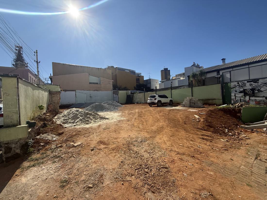 O lote a leste hoje: terra batida, areia e brita, cercado pelas empenas dos vizinhos.